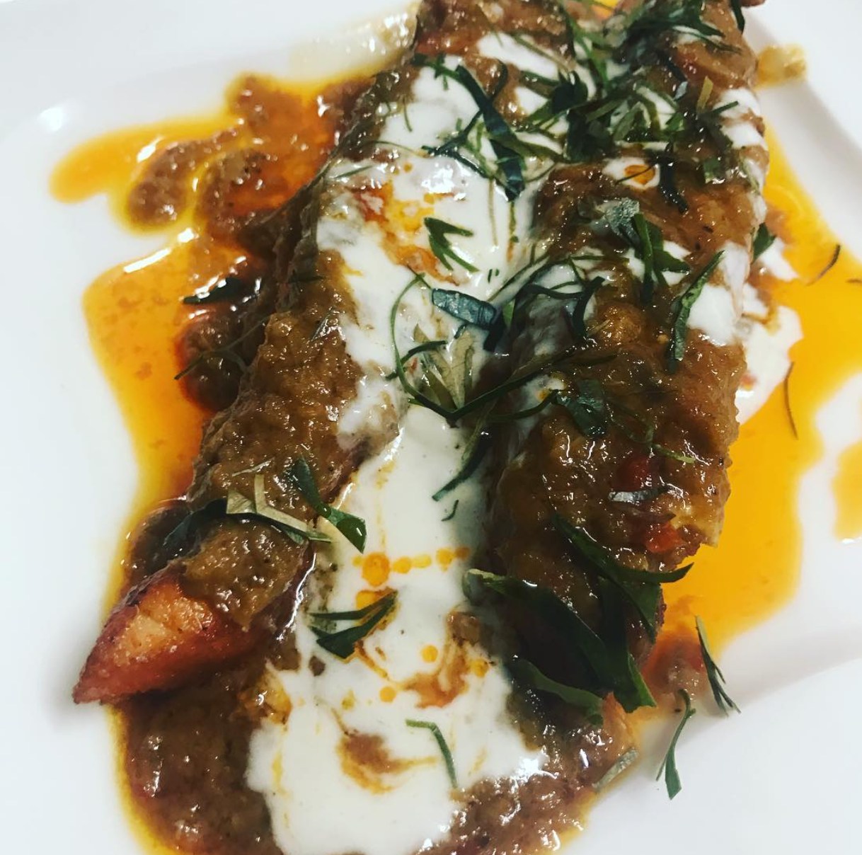 Fischfilet unter roter Currysauce mit Kokossahne und Kräutern