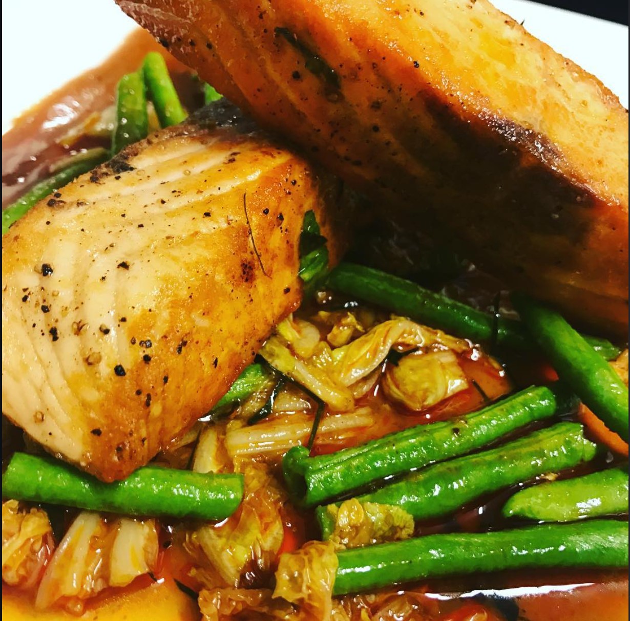 Gebratenes Lachsfilet mit grünen Bohnen in glänzender Chilisauce